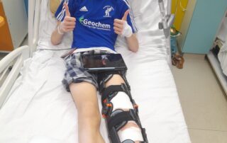 Paediatric patient wearing knee brace following ACL surgery.